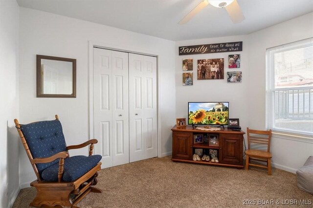 living area featuring carpet flooring, a ceiling fan, and baseboards