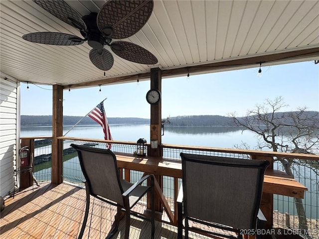 wooden terrace with a ceiling fan and a water view