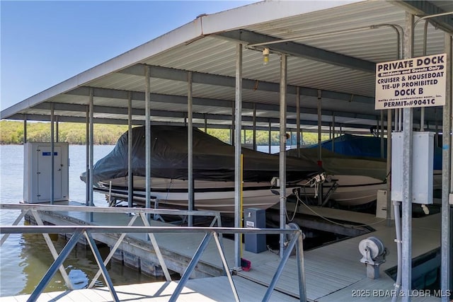 dock area featuring boat lift and a water view