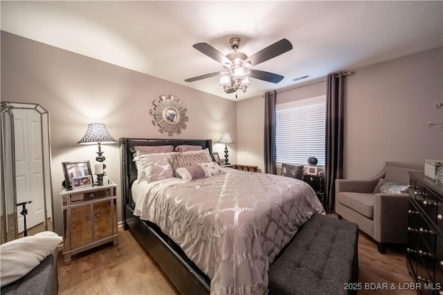 bedroom with ceiling fan, visible vents, and light wood-style flooring