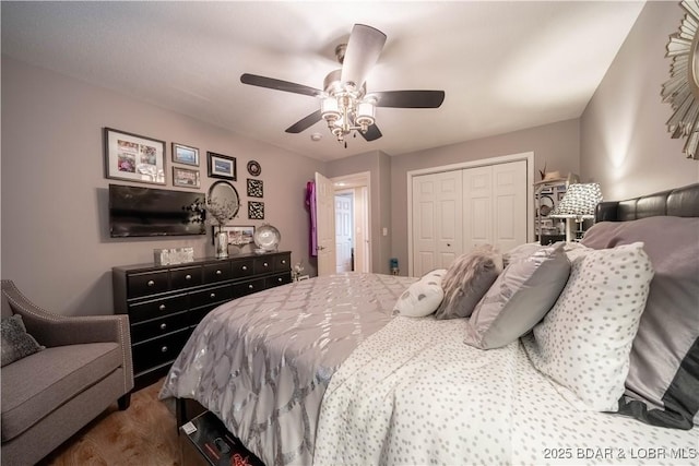 bedroom featuring a ceiling fan, a closet, and dark wood-style flooring