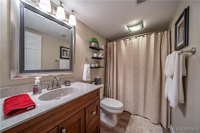 full bathroom featuring vanity, wood finished floors, visible vents, a textured ceiling, and toilet