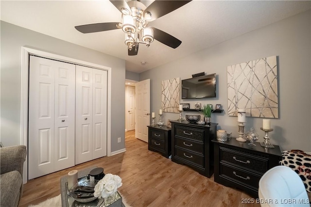 bedroom with a closet, light wood-style flooring, and ceiling fan