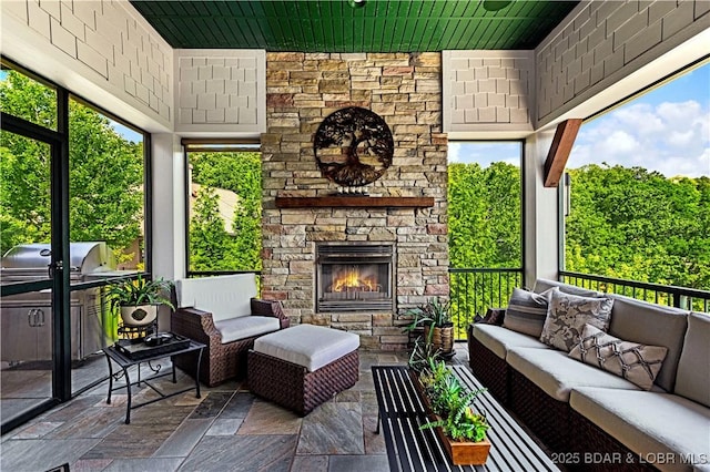 sunroom with an outdoor stone fireplace