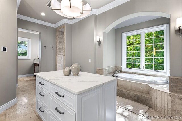 full bathroom with baseboards, a garden tub, ornamental molding, and vanity