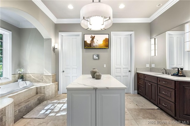 bathroom with recessed lighting, ornamental molding, vanity, and a bath