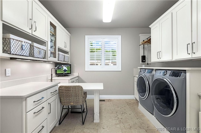 laundry area with washer and dryer, baseboards, and cabinet space