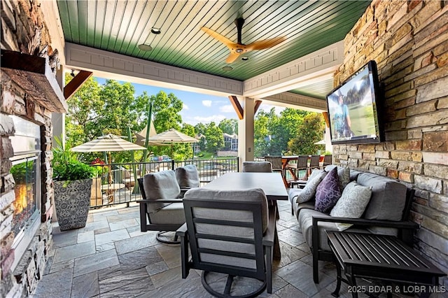 view of patio with outdoor dining space, ceiling fan, and an outdoor hangout area