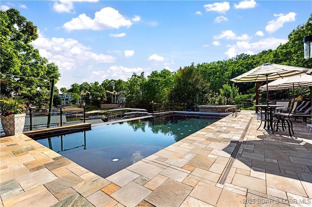 pool with outdoor dining area and a patio