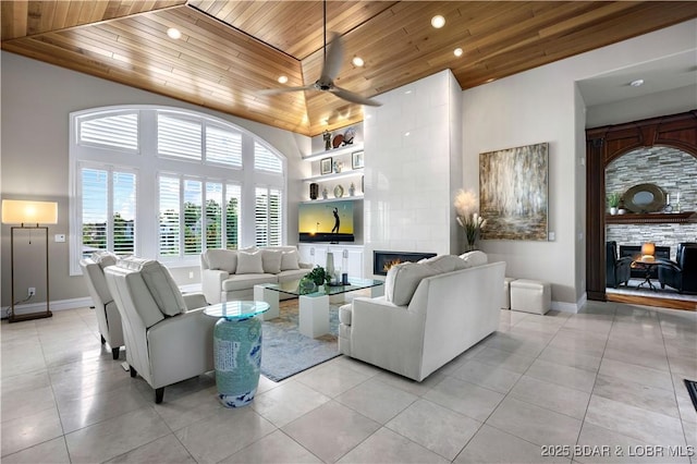 living area with light tile patterned floors, high vaulted ceiling, a tile fireplace, and wood ceiling