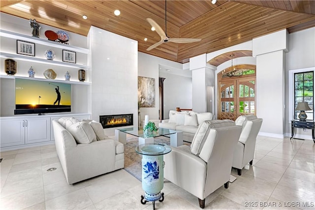 living room featuring light tile patterned floors, high vaulted ceiling, wood ceiling, and a tile fireplace