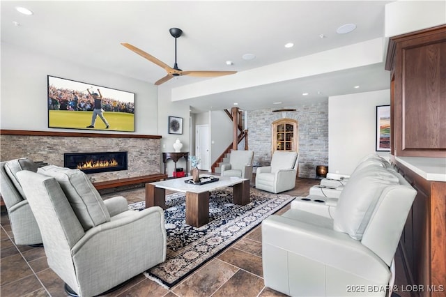 living room with recessed lighting, stairs, a glass covered fireplace, and a ceiling fan