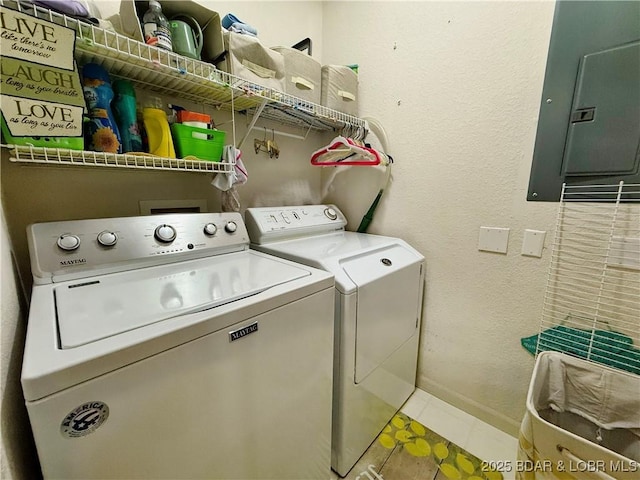 laundry room featuring electric panel, baseboards, washing machine and clothes dryer, laundry area, and a textured wall