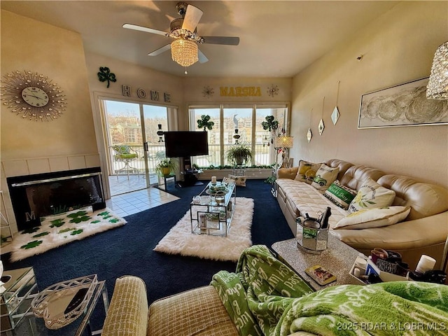 carpeted living room with a fireplace and ceiling fan