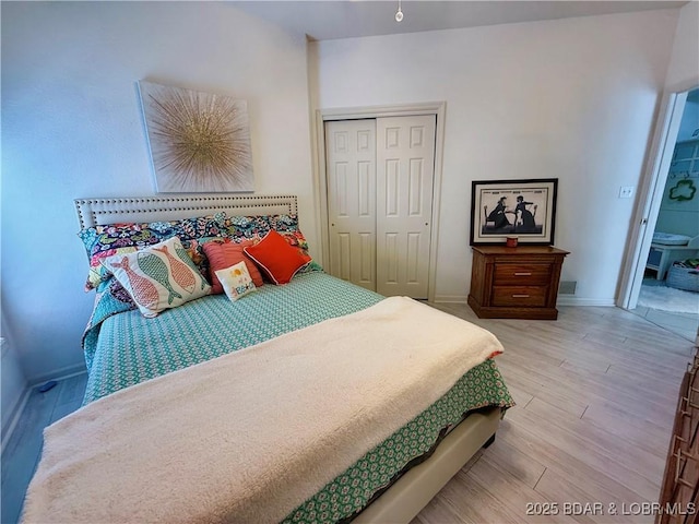 bedroom featuring a closet, baseboards, and wood finished floors