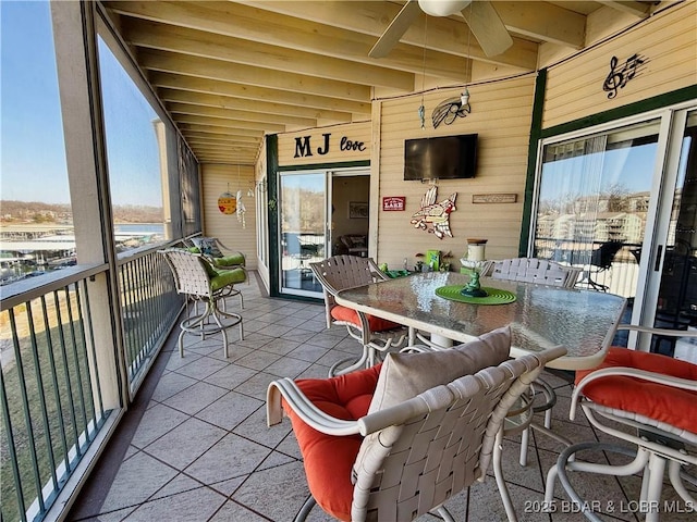 sunroom / solarium featuring beam ceiling and ceiling fan