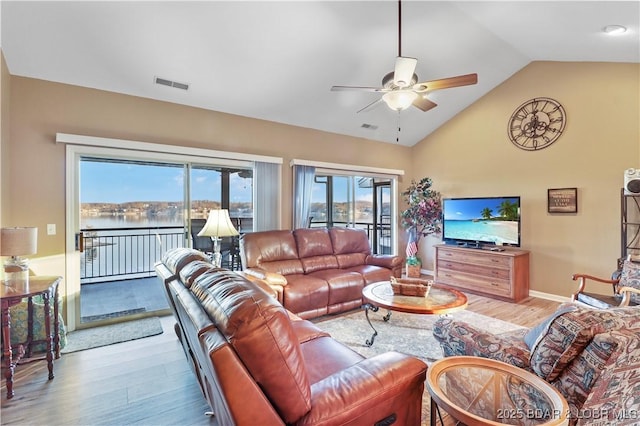 living area featuring wood finished floors, a ceiling fan, visible vents, and vaulted ceiling