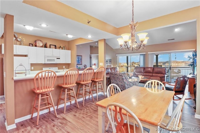 dining space featuring light wood finished floors, visible vents, baseboards, recessed lighting, and a notable chandelier