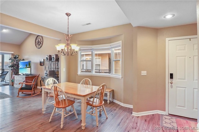 dining area featuring visible vents, a notable chandelier, wood finished floors, and baseboards