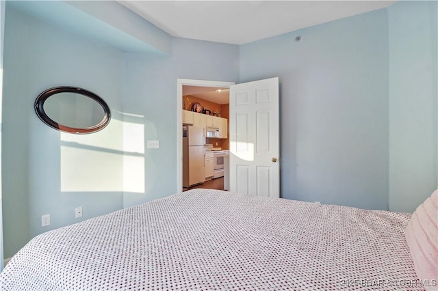 bedroom with freestanding refrigerator