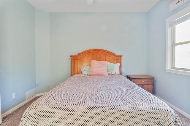 carpeted bedroom with visible vents and baseboards