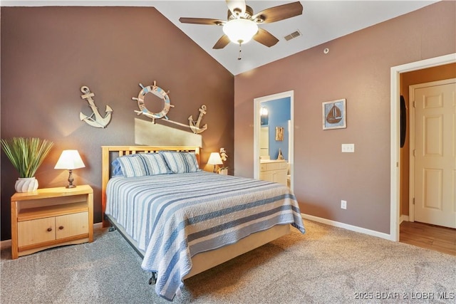 carpeted bedroom with visible vents, ceiling fan, baseboards, lofted ceiling, and ensuite bath