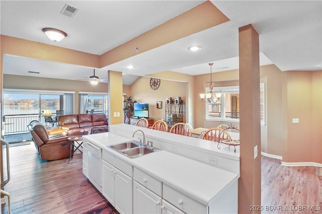 kitchen featuring a sink, light wood-style floors, dishwasher, and white cabinets