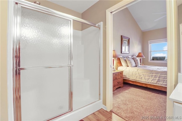 ensuite bathroom with a shower stall, ensuite bath, and vaulted ceiling