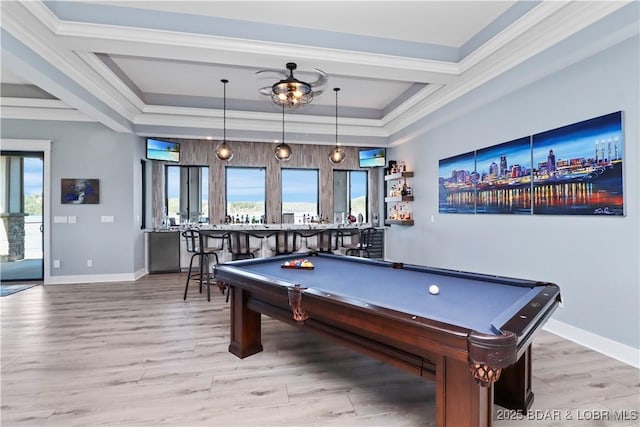 recreation room with crown molding, wood finished floors, baseboards, and a raised ceiling