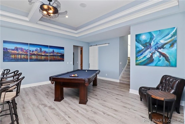 playroom featuring light wood-type flooring, a barn door, baseboards, and ornamental molding