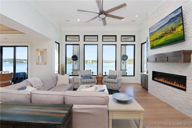 living area featuring recessed lighting, a fireplace, light wood finished floors, and ceiling fan