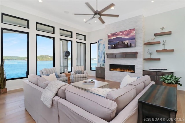 living room with a fireplace, recessed lighting, wood finished floors, and a healthy amount of sunlight