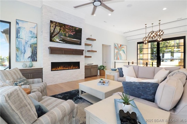 living area with recessed lighting, a large fireplace, a ceiling fan, and wood finished floors