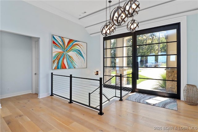 interior space with a chandelier, baseboards, and wood finished floors