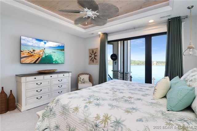 bedroom featuring access to exterior, a water view, light colored carpet, wood ceiling, and a raised ceiling