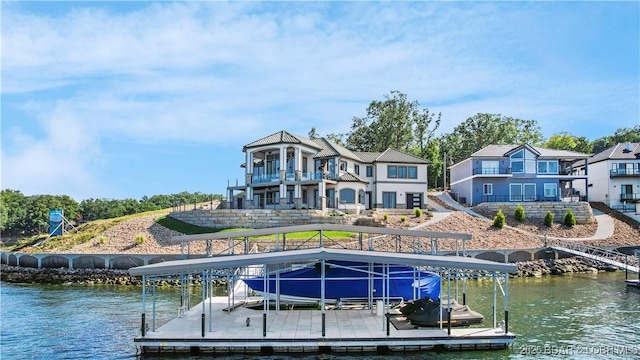 dock area featuring boat lift, a balcony, and a water view