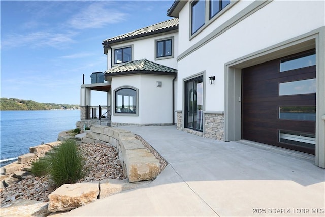 exterior space with a garage and a water view