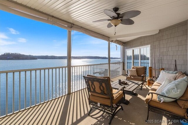 exterior space with an outdoor living space, a ceiling fan, and a water view