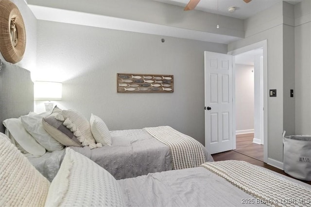 bedroom featuring a ceiling fan, baseboards, and wood finished floors