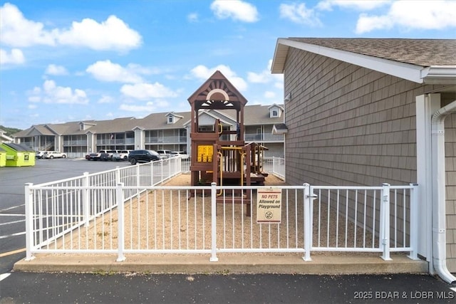 community play area with fence and a residential view