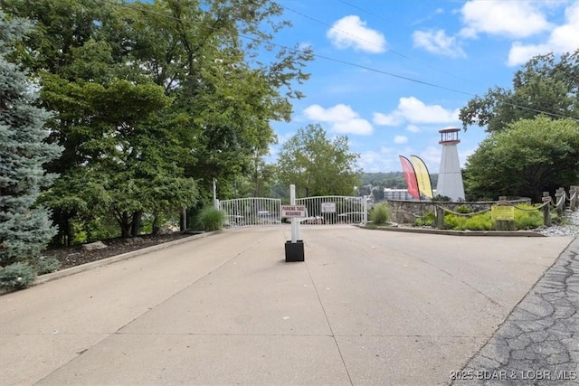 view of road featuring a gate, curbs, and a gated entry