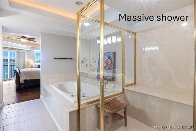 ensuite bathroom with tile patterned floors, connected bathroom, a bath, and ceiling fan