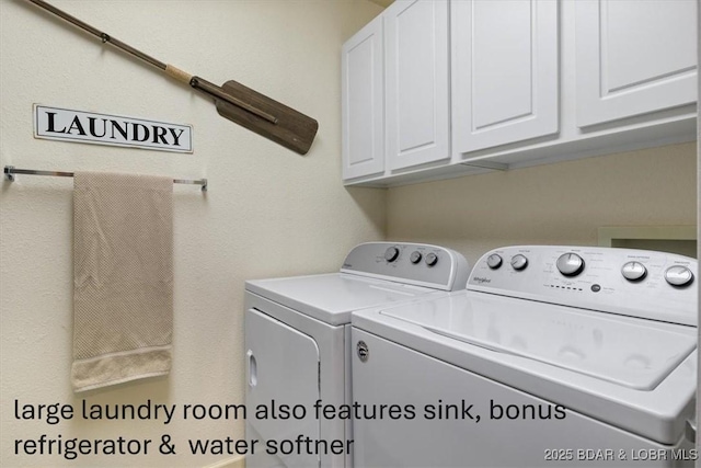 clothes washing area featuring washing machine and clothes dryer and cabinet space