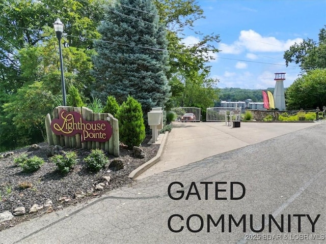 community / neighborhood sign featuring fence