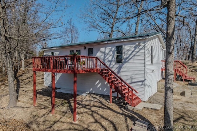 back of house featuring stairs and a deck