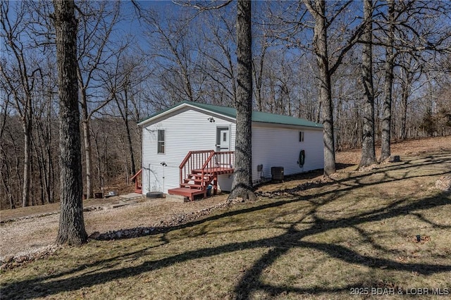 view of front of property with central AC unit and a front lawn