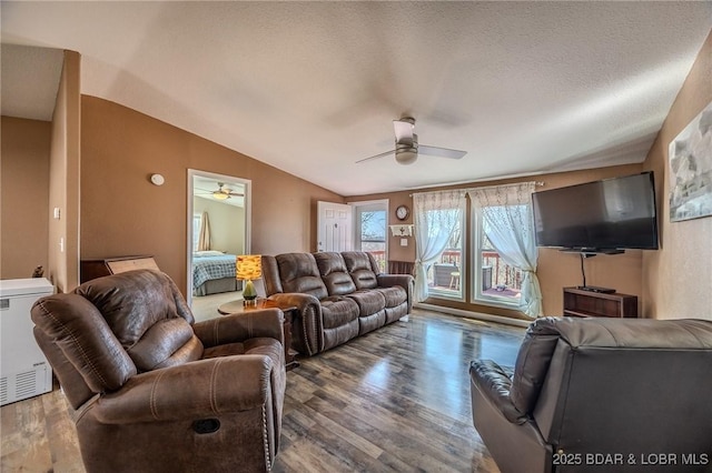 living room with ceiling fan, lofted ceiling, wood finished floors, and a textured ceiling