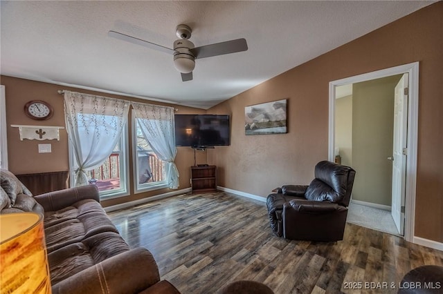 living room with baseboards, lofted ceiling, wood finished floors, and a ceiling fan