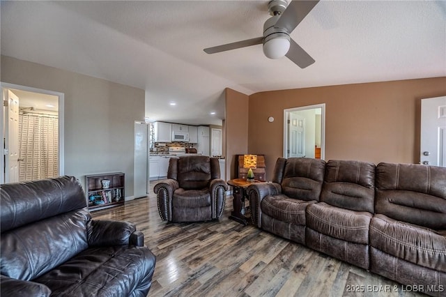 living area with ceiling fan, lofted ceiling, wood finished floors, and recessed lighting