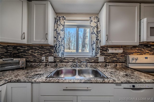 kitchen with white appliances, a toaster, a sink, white cabinetry, and backsplash